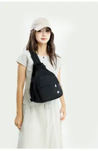 Detailed view of the trendy black chest bag worn by model, showcasing lightweight sling design.