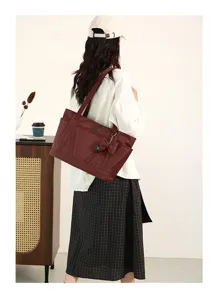 Detail view of the large capacity wine red tote bag with bow accent and comfortable shoulder strap.