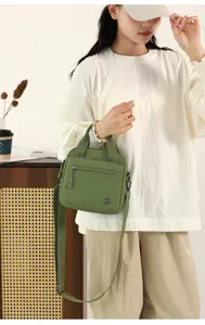 Green canvas crossbody bag, lightweight casual shoulder handbag with top handle and pocket.