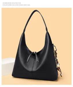 Detailed view of the black leather hobo shoulder bag with zipper closure and charm strap.