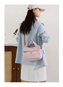 Pink nylon crossbody shoulder bag detail, multi-compartment design for daily casual use.