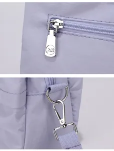 Detailed view of women purple nylon shoulder bag zipper and metal hardware accents.