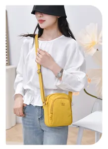 Detailed view of yellow nylon cross-body bag worn by model, casual design with multi-layer storage.