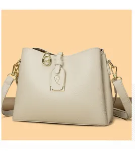 Elegant beige leather shoulder bag with chic metal pendant for women daily commute