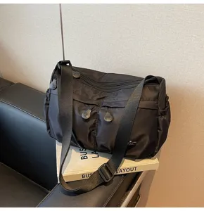 Sac bandoulière décontracté en nylon noir avec plusieurs fermetures éclair pour commuter.
