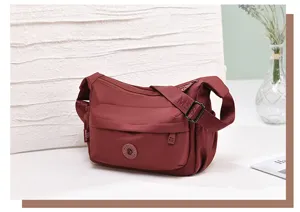 Detailed view of wine red nylon crossbody shoulder bag with multi-pockets and durable strap.