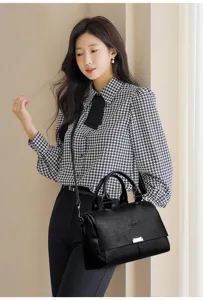 Stylish black leather tote bag for women, large capacity commuter handbag with shoulder strap.