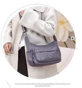 Detailed view of grey nylon shoulder bag with front pocket and strap. Perfect daily style.