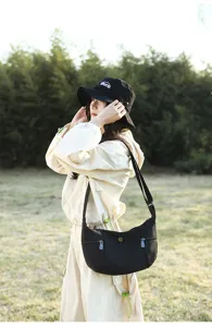 Casual canvas crossbody bag detail shot, showing adjustable strap and pocket in outdoor setting.