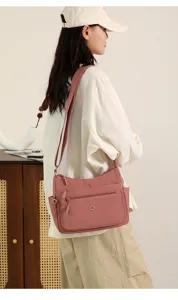 Casual pink canvas shoulder bag detail showing multi-pocket design and adjustable strap.