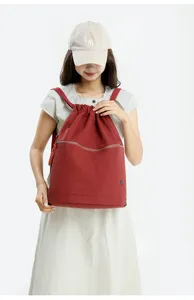 Detailed view of red drawstring backpack, casual sports style, perfect for daily wear scene.