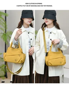 Detail view of casual yellow nylon crossbody tote bag with adjustable shoulder strap and pockets.