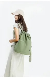 Olive green drawstring backpack detail shot, large capacity gym rucksack for women daily use.
