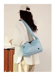 Closeup detail of the light blue nylon crossbody bag, showing durable messenger style design.