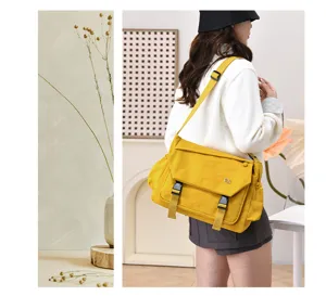 Detailed view of a yellow canvas messenger bag with double buckles, perfect for daily commuting.