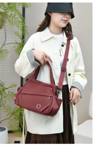 Detail view of the casual nylon crossbody bag in burgundy, featuring sturdy straps and ample space.