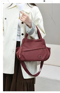 Detail view of the casual nylon shoulder bag in burgundy, showing large capacity and strap.