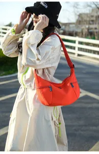 Minimalist orange crescent crossbody bag detail, casual canvas shoulder bag for women.