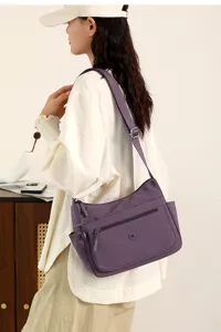 Detailed view of the casual purple crossbody shoulder bag worn by model, lightweight design.