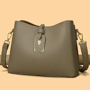 Stylish taupe leather crossbody shoulder bag with elegant rose charm and gold hardware for women.