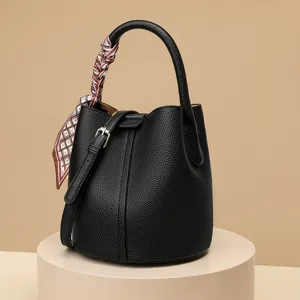 Classic black leather bucket bag with top handle and printed silk scarf, chic main view