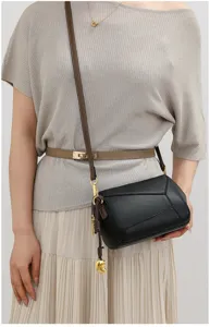 Elegante schwarze geometrische Ledertasche Damen, modische Umhängetasche mit braunem Schultergurt.