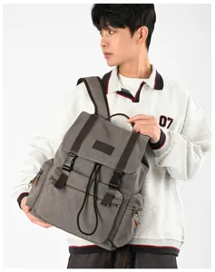 Detailansicht des lässigen Canvas-Rucksacks mit braunen Lederriemen und mehreren Taschen.