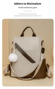 Schicker Damen Fareblock Rucksack mit flauschigem Bommelanhänger, ideal für Alltag und Pendeln.