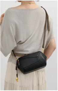 Detailansicht der schwarzen geometrischen Damen Leder Umhängetasche mit verstellbarem Riemen.