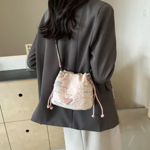 Stylish pink bucket bag for women with chain strap and trendy embroidered details.