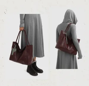 Close-up detail of the large maroon leather tote bag, showing shoulder wear and hand carry.