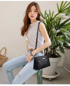 Detailed view of women's black soft leather crossbody bag lifestyle shot with model