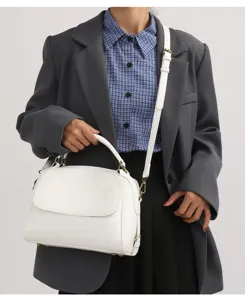 Dettaglio borsa a tracolla in pelle PU bianca con cinturino regolabile e design con patta.
