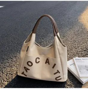 Large capacity canvas tote bag for women, stylish shoulder bag with brown handles and letters.