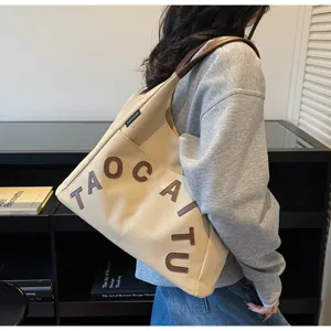 Beige canvas tote bag for women, large capacity shoulder bag with stylish brown letters design.