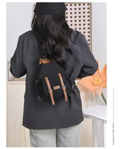 Schwarzer Nylon Mini Rucksack Detail mit Vintage braunen Lederriemen Metall Schnallen.