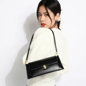 Chic black leather shoulder bag for women, minimalist baguette design with gold hardware.