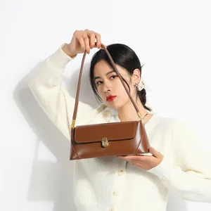 Detailed view of brown leather shoulder bag, elegant flap design with metal lock for women.