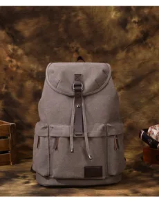 Zaino vintage in tela grigia con cinghie in pelle marrone, perfetto per gli spostamenti.