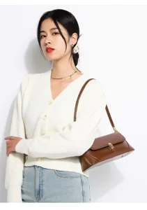Detailed view of women's brown soft leather shoulder bag with chic metal lock detail.