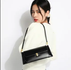 Elegant black leather shoulder bag for women, featuring a chic metallic lock and slim strap design.