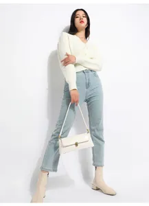 Minimalist white shoulder bag detail, soft leather texture, elegant metal lock design.