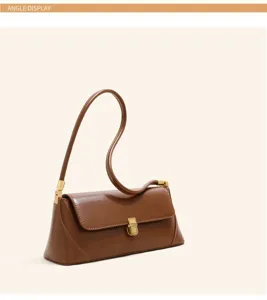 Brown leather shoulder bag detail, elegant baguette bag with metal lock, chic daily wear.