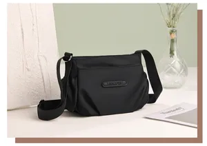 Detailed view of the black nylon casual crossbody shoulder bag with stylish strap and front pocket.
