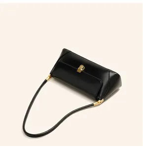 Detail view of a black soft leather shoulder bag with gold-tone hardware and chic clasp.