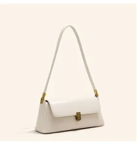 Close-up of the cream shoulder bag strap connector and exquisite vintage brass lock detail.