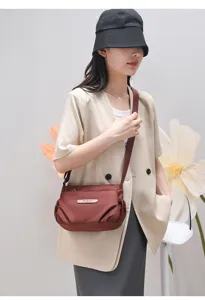 Detail view of casual women's burgundy crossbody shoulder bag, lightweight and fashionable daily wear.