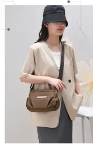 Detail view of the stylish brown casual crossbody bag with durable woven strap and label.