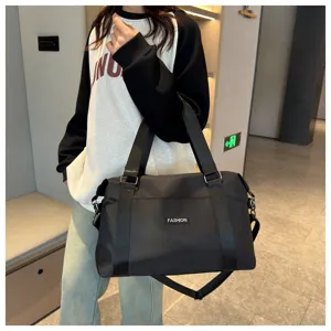 Detail view of the black travel duffel bag showing durable fabric handles and spacious capacity.