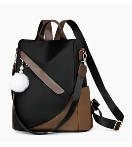 Detailaufnahme des stilvollen schwarz-braunen Damen-Rucksacks mit flauschigem Bommel.